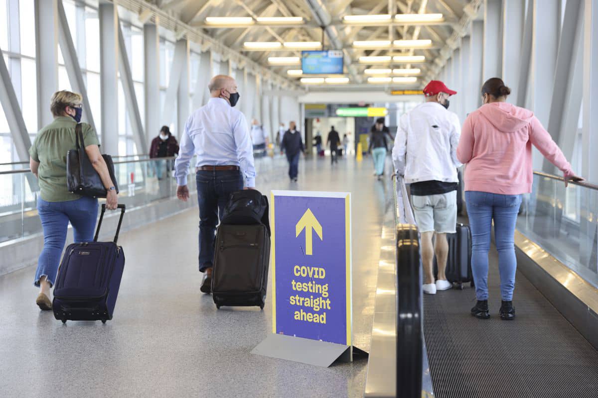 Travelers wearing protective masks at John F. Kennedy International Airport (JFK) in New York, U.S.