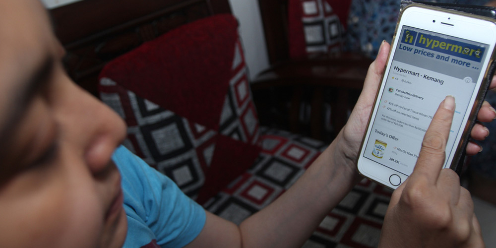 A woman using an online shopping app from her smartphone, in Jakarta.