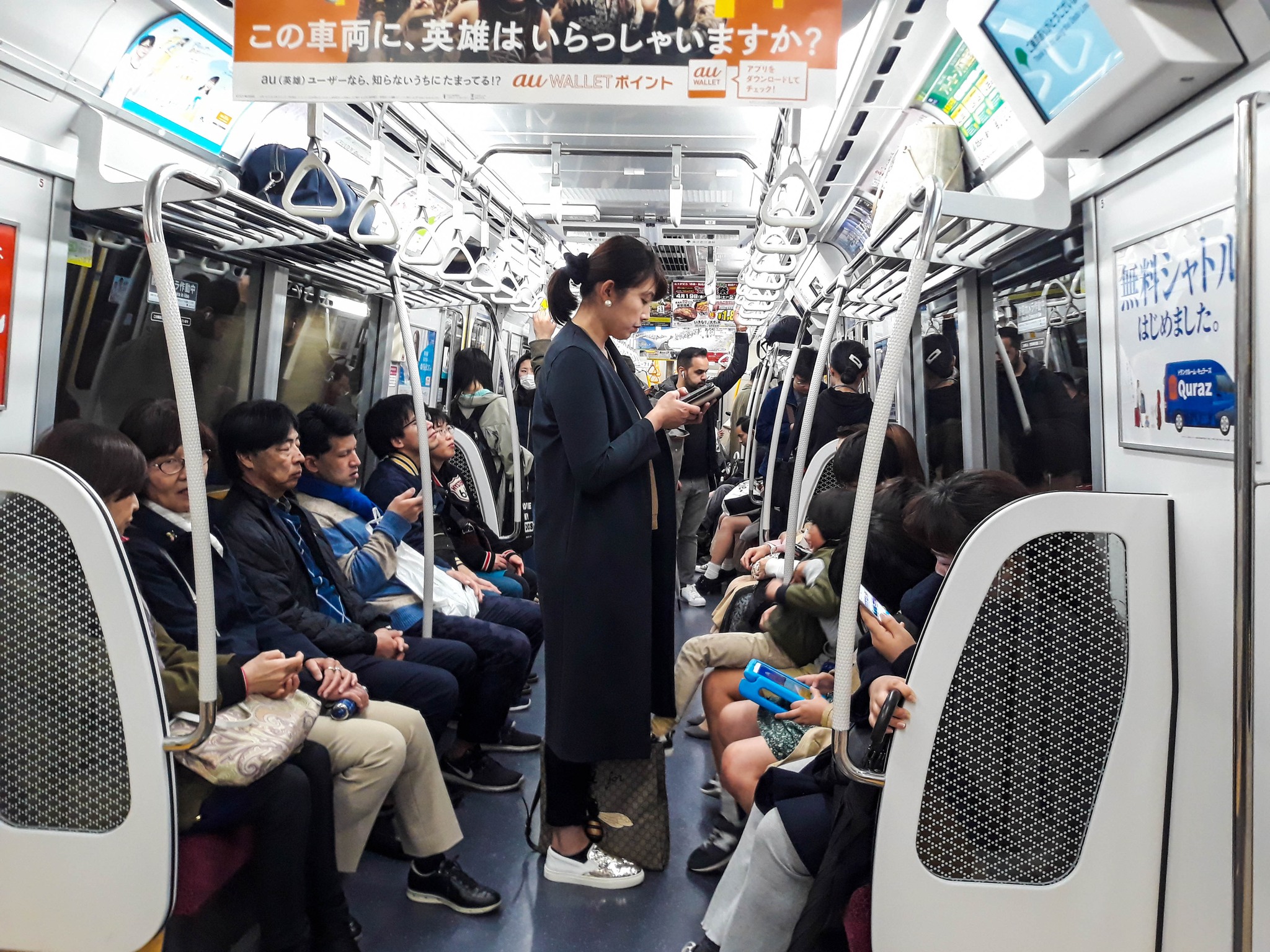 Woman holding smartphone in public.